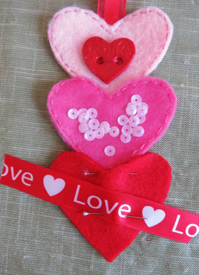 Just like you did before, tuck the point of the second heart between the pieces of the third heart before you sew them together.