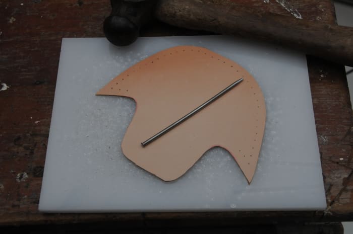 Use either a leather punch or a rotary punch to cut even holes around the top of the boot.