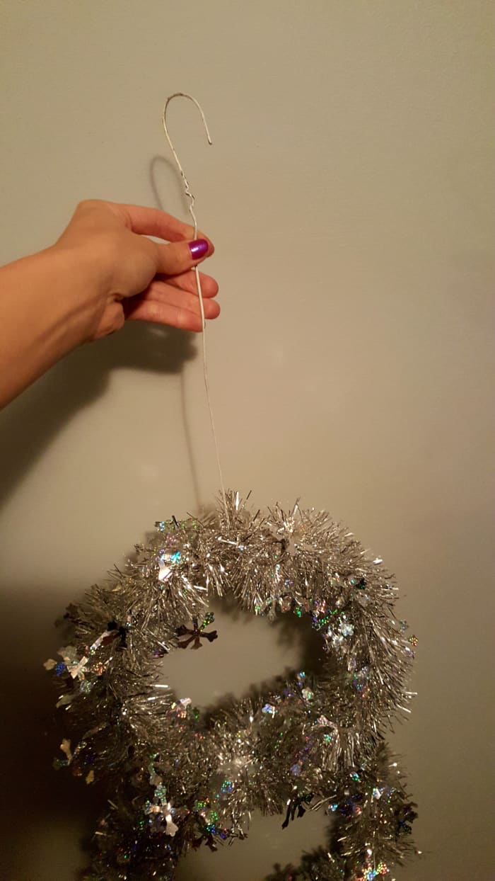 Use any left over wire hanger pieces to create a hook. Or create a hook using your floral wire. Attach to the middle of your top circle to hang your snowman.