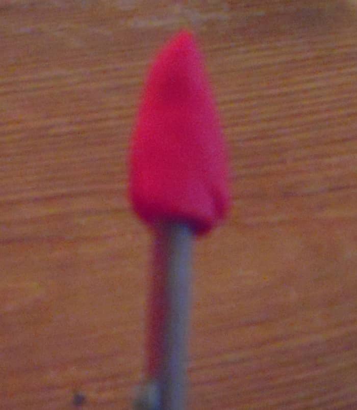 Attach the "jumbo pea" sized piece of clay to stick, shaping the clay into a cone with a soft pointed tip.