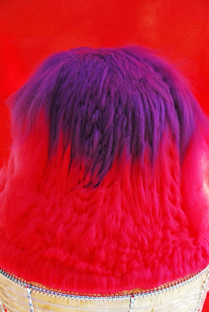 Needle felt the loose fibres onto the hat block adding the layers one by one. Use whichever color pleases the eye.