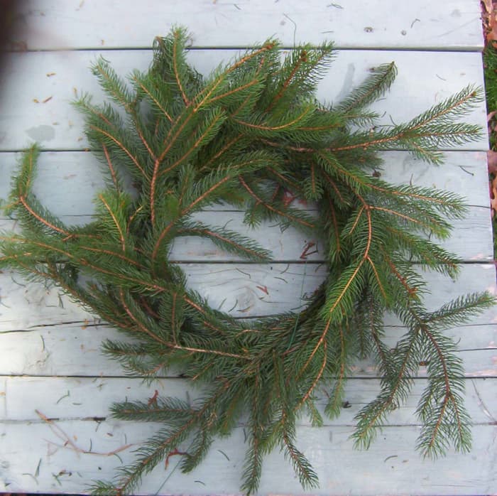 Loose evergreen pieces can be secured with wire or tucked into the other branches