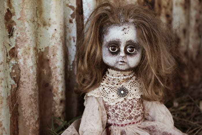 Add some spooky-looking dolls: Use makeup, paint, flour, etc. to turn a regular doll into a zombie doll.