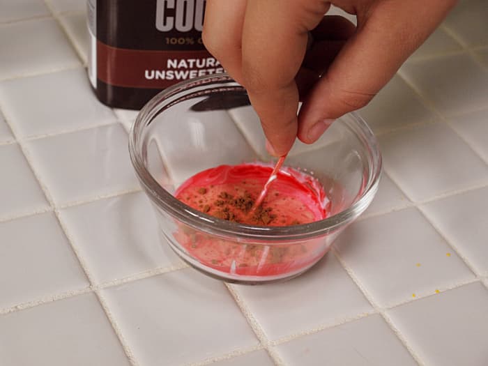2. Mix with a toothpick and add some cocoa powder to darken. Start with a little cocoa powder. You can always add a little more to make it darker.