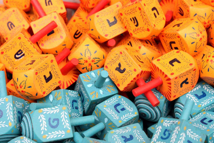 Dreidels for sale in Jerusalem, Israel with נ ג ה פ on the blue dreidels and נ ג ה ש on the orange dreidels.