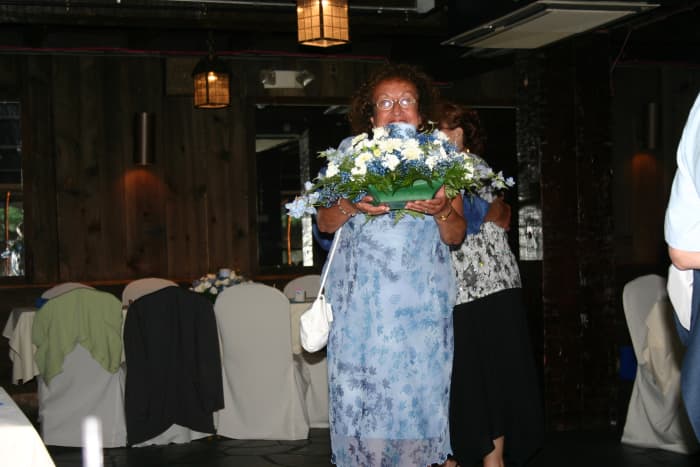 A happy Wedding Reception Trivia Game winner taking her prize centerpiece home at the end of the reception!