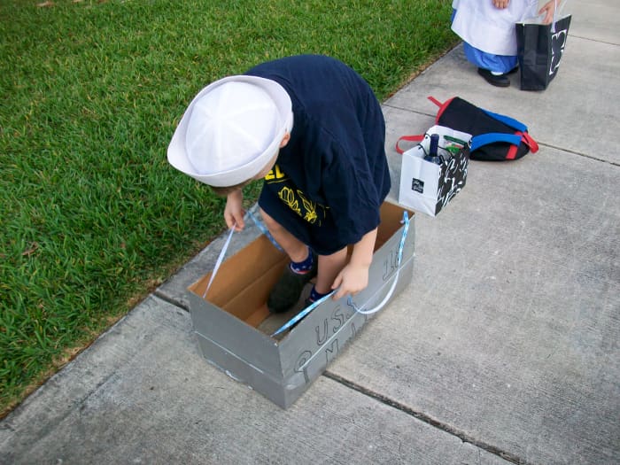 Attach the straps to the front and back of the box so your child can support the boat on his shoulders.