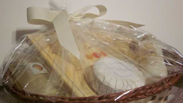 This basket contains cream and yellow colored items which include: vanilla and citrus-scented products and an inpsirational book.