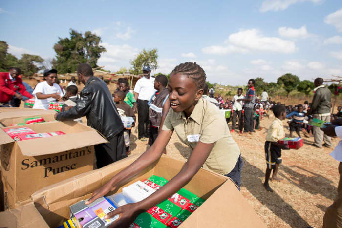 Angella, a 13-year-old girl from Malawi who received a shoebox herself the year before this photo was taken, helps distribute gifts.