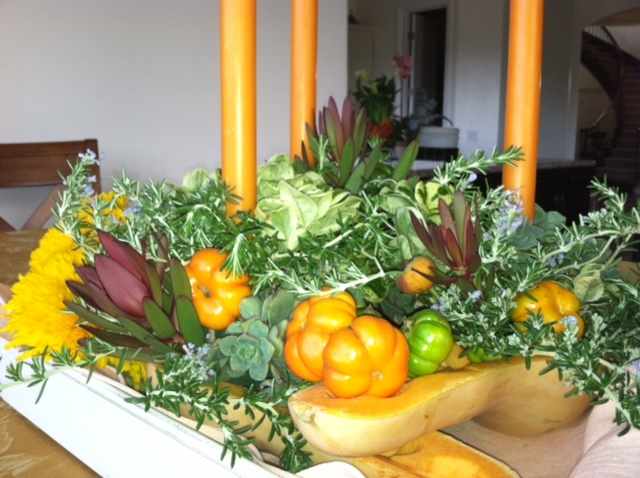 This Thanksgiving centerpiece features seasonal gourds and succulents. Look closely to discover the use of succulents as fillers. They provide a vibrant pop of color. Rosemary (also considered drought-resistant) makes a good filler too.