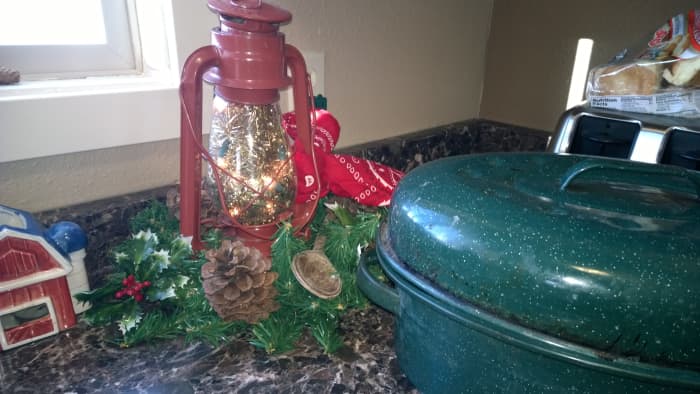 This old red lantern was cleaned up and dressed with garland, pine cones, a red bandanna, and filled with a short string of warm Christmas lights.