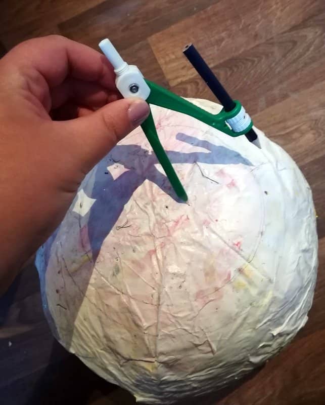 I like to use a pencil in a compass to draw a perfect circle on my paper-covered ball. This circle will become the pupil of the eye.