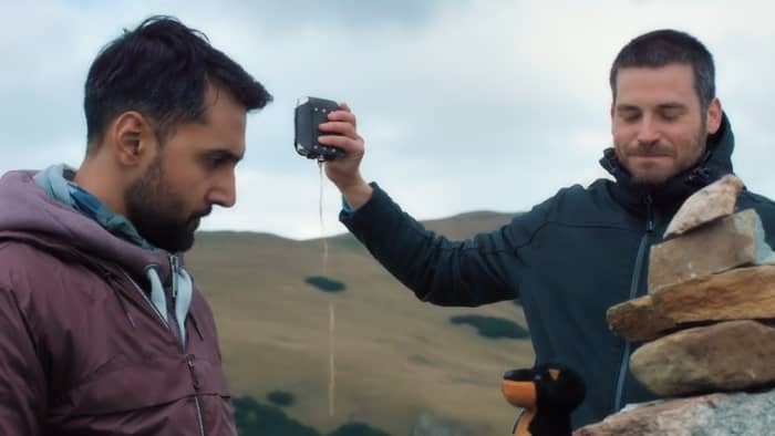 Arsher Ali as Phil and Rob James-Collier as Hutch pour one out in honor of their friend, Robert, in 'The Ritual' (2018), a Netflix Original.