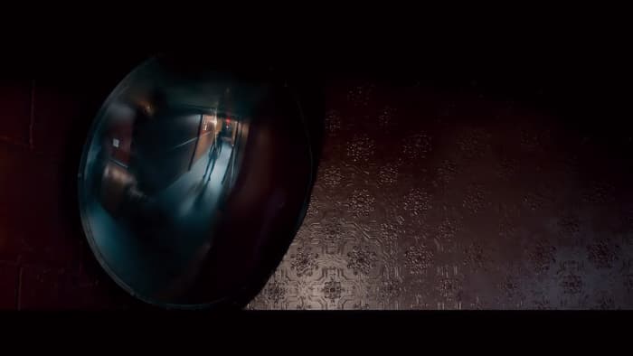 A figure appears in a hallway security mirror inside the Tilden Morgue. 'The Autopsy of Jane Doe' (2016)