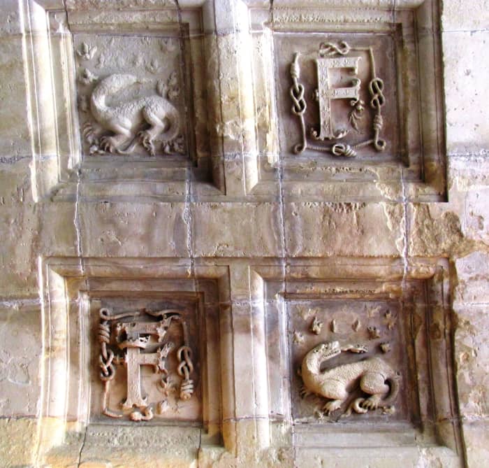 Ornate carvings of salamanders and the king's initial on the ceiling of the third floor.