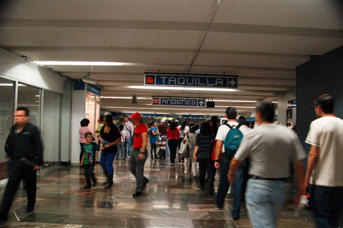 Look at the first blue sign. It says "taquilla" the Spanish word for ticket booth. The other word "Andenes" lets you know the direction in which the tracks are.