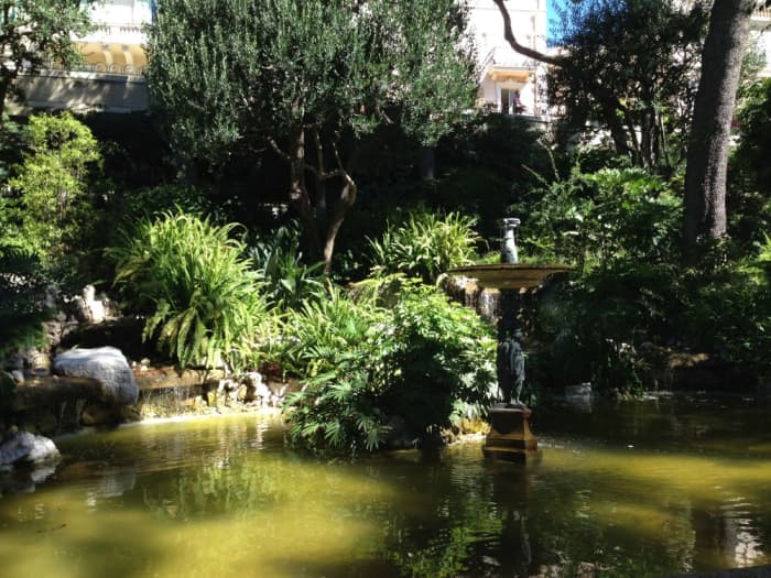 Part of the Jardins Saint Martin in Monaco-Ville, with trees, bushes and ferns surrounding a pond