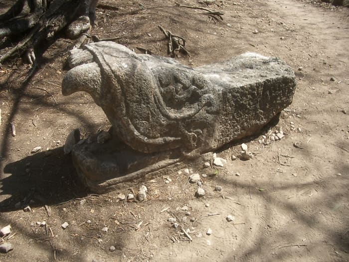 The stone head of Kukulcan. Not yet reconstructed, we saw it on the trail in Old Chichen.