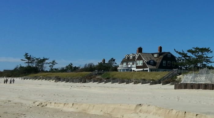 The Saltbox style house, a staple of American colonial architecture, features a steeply sloping roof which tapers down from two stories to one.