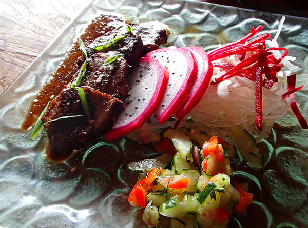 Bali Tataki plate of cacao & cayenne seared tuna in mangosteen sauce, with daikon, dragonfruit, and beet salad at Clear Café.