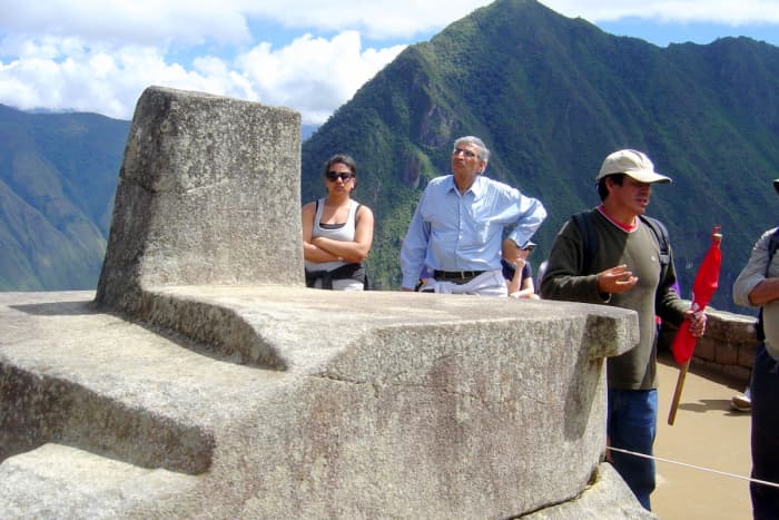 Tourists admiring the handiwork of the Inca workmen who created the so-called "compass rock," whose points are lined up with the points of a compass, including one which is apparently aligned with magnetic north.