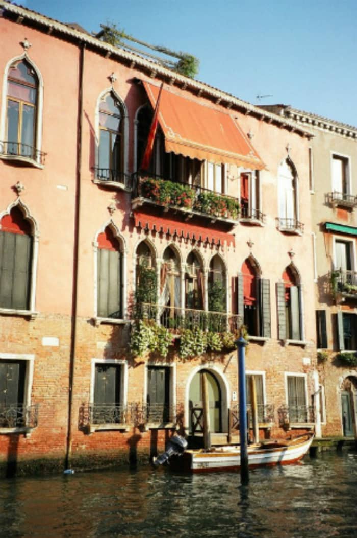 A beautiful home with Moorish architecture and vivid colors on a canal in Venice. Its small motor boat waits at the doorstep to provide transportation for its owners.