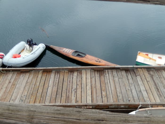 Several types of dinghies were parked at a dock in the marina. They were used to paddle out to anchored boats.One was an attractive, handmade wooden kayak.