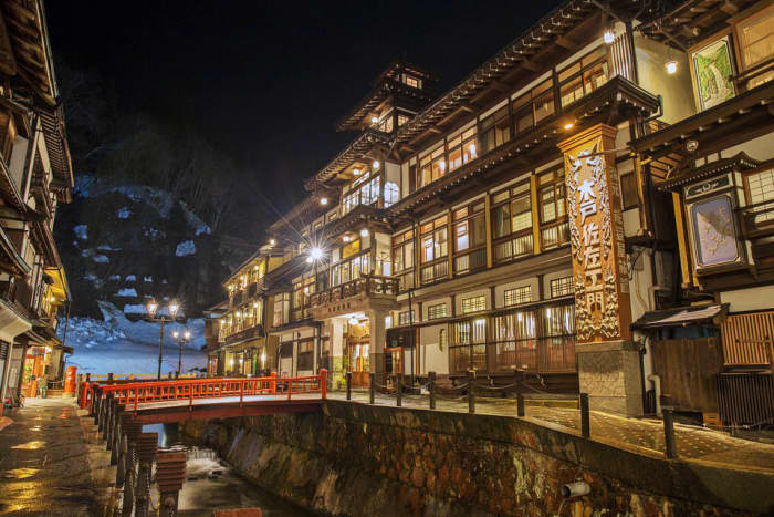 Some onsen (hot spring) ryokans offer kashikiri yu, which are private onsen rooms for rental. That's your solution if your body art isn't welcomed elsewhere.
