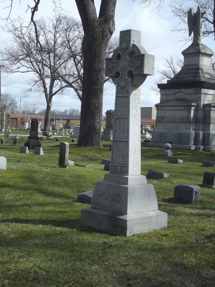 Image of Celtic cross monument in granite with Celtic knots carved in relief. Hume family plot, Evergreen Cemetery, Muskegon, MI.