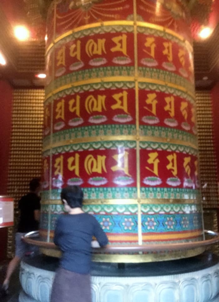The prayer wheel in the rooftop garden of the Buddha Tooth Relic Temple, Singapore. According to the Buddhist tradition spinning a prayer wheel will have much the same meritorious effect as orally reciting the prayers.