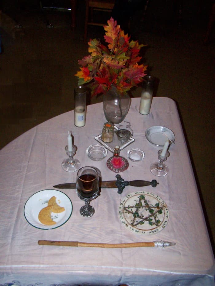 This is my esbat altar. It's fairly simple: God & Goddess candles, athame, cup of wine, wand, pentacle, cakes, fire candle, incense, small bowls of water & salt. Other candles & flowers for decoration. But I could omit any or all tools