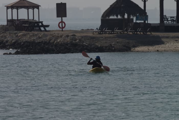 My younger brother pedals his kayak from quite far off in the waters back to our picnic spot (April 2016).