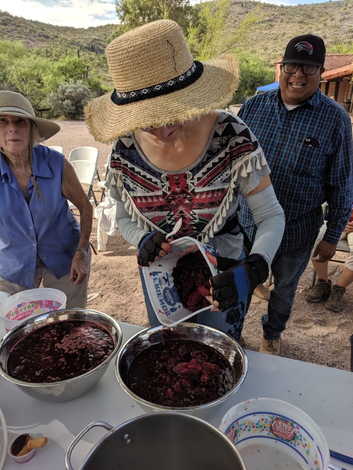 Returning from the desert with the fruit we had harvested. My wife pours the fruit we gathered into communal pot for the syrup.