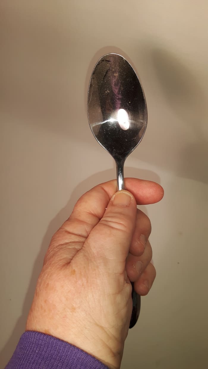 Hold the spoon in your dominant hand, the one with which you write. Hold the spoon with the bowl of the spoon at the top.