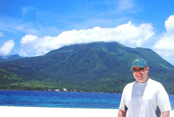 This is a photo of me after I went scuba diving at White Island, with Camiguin Island in the background.