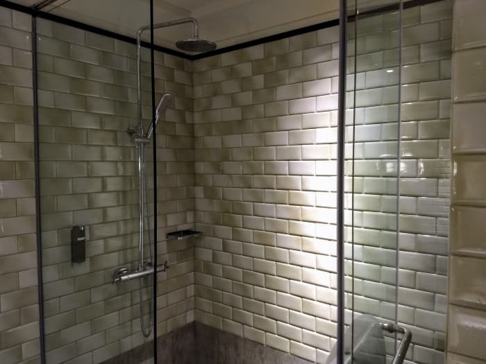 Shower stall to the right with a rain showerhead and hand-held shower.