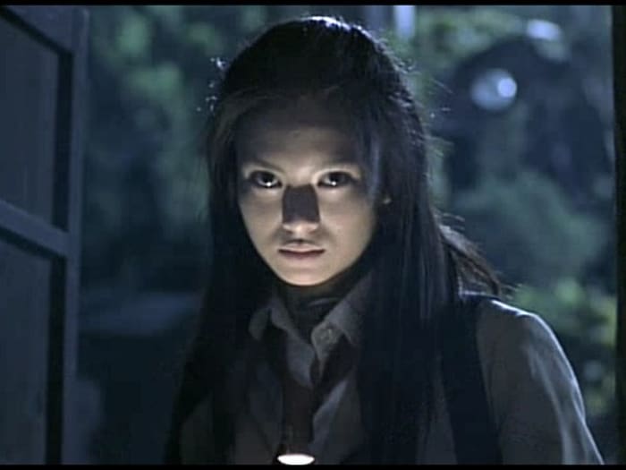Chiaroscuro lighting from flashlight to demonize Mitsuko. Unintentionally similar to Warwick Davis's Leprechaun.