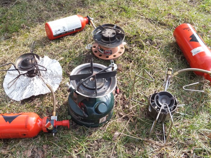 Four white gas stoves: MSR Whisperlite (international), Coleman Peak 1, Coleman Exponent Apex II, and MSR Dragonfly.
