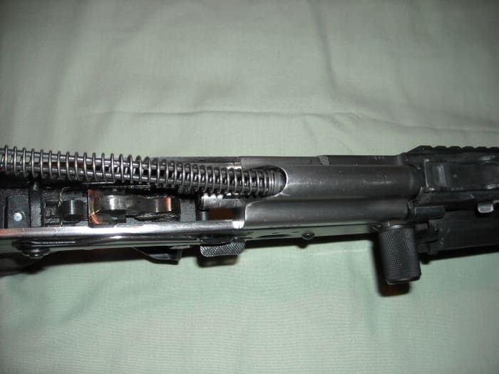 Insert the buffer spring assembly into the rear opening of the bolt carrier group.