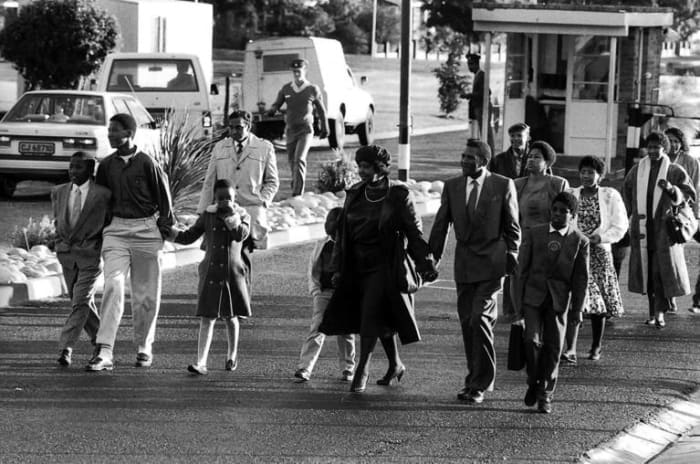 Winnie Madikizela-Mandela, center, holding the hand of her son, the late Makgatho Mandela, and family walk out of Victor Verster Prison after visiting her husband Nelson Mandela. Mandela spent the last three of his 27 years behind bars at Victor Vers