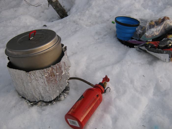 Melting snow using the MSR dragonfly on a winter backpacking trip. The blue sea to summit cup is used for dipping boiling water into water bottles.