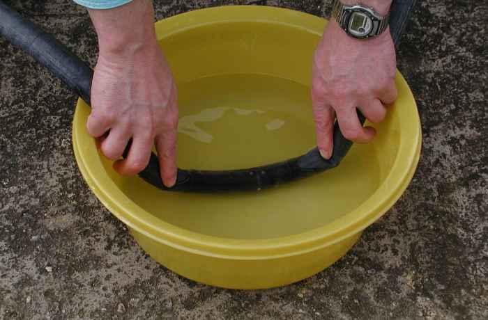 You should see bubbles of escaping air indicating the position of the hole