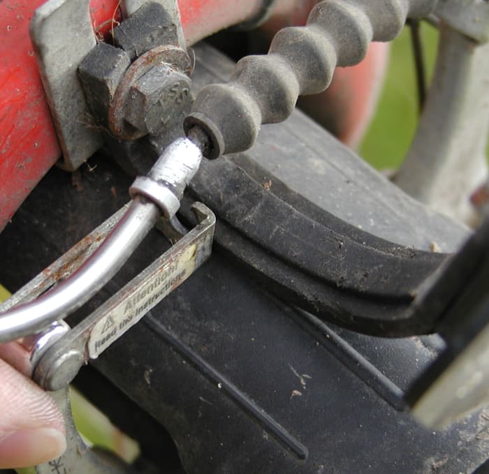 Removal of brake cable from V-brake also known as side pull or direct cantilever brake. Hold the linkage on the brake arm, pull the brake cable sleeve and lift it clear of the linkage.