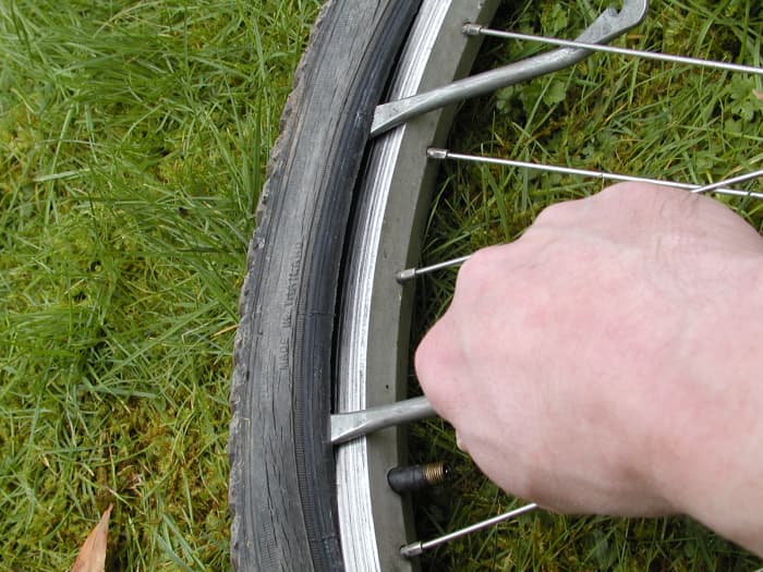 Slide the tire lever along the bead to release it. You may need to lever out further sections of the tire, bit by bit with the second lever before it is possible to do this, especially if the tire is a tight fit or rigid due to low temperatures