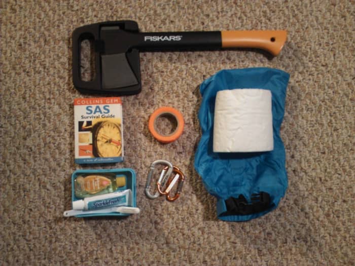 From left to right: hatchet, survival manual, dental hygiene kit, duct tape, carabiners, and toilet paper.