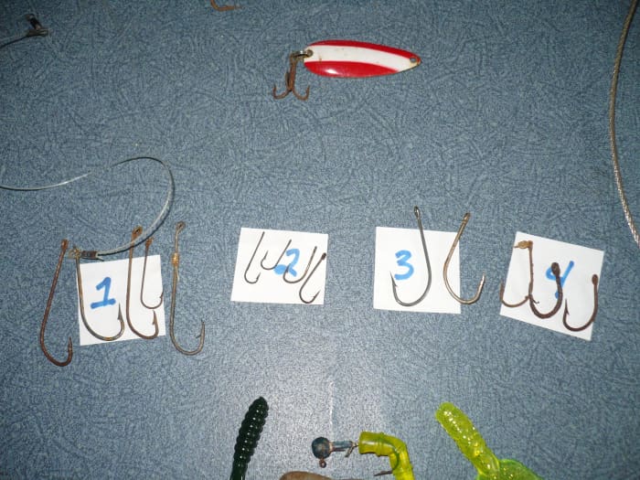 Salt water fishing hooks: J-hooks, hooks with barbs on their backs, and smaller bait hooks.