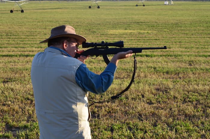Tom, a left-handed shooter, observes my point of impact ("spotting the shot") and advises that my shot was high.