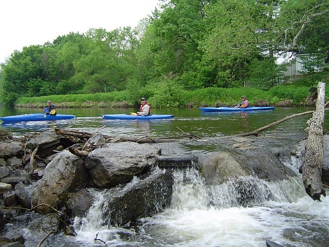 Pausing above a weir. Such a spot is a good place to take the boat out of the water and port on shore around the obstacle.