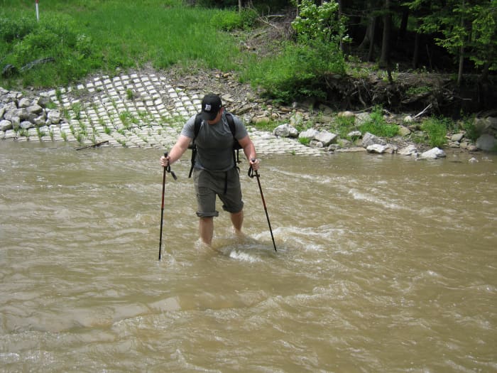 Trekking poles not only help in balance but are essential if you on making a difficult stream crossing. Here, a friend is crossing a stream with his Leki trekking poles.
