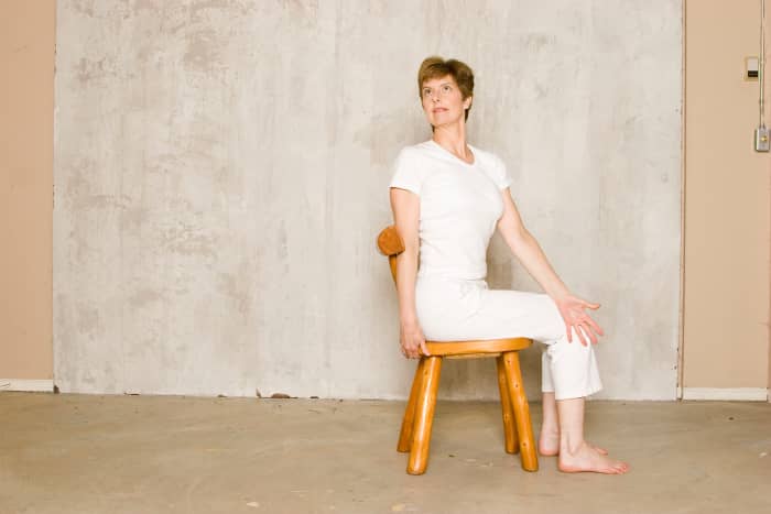 Seated Twist in a Chair. As you inhale, lift the ribs away from the hips and lengthen the spine. As you exhale, twist back gently leading the twist with the shoulder.